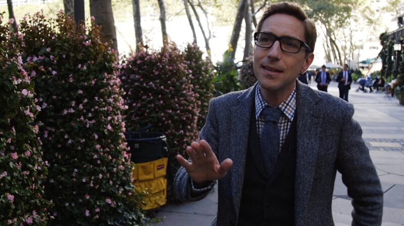 Well dressed man standing on the sidewalk in NYC